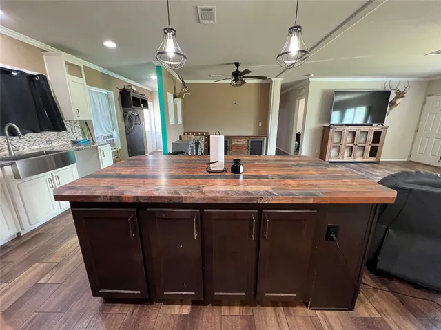 a kitchen with a sink a refrigerator and wooden floor