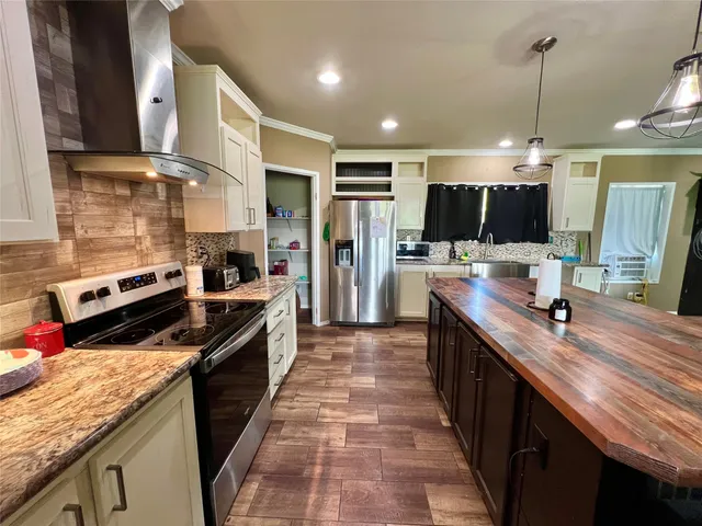 a large kitchen with stainless steel appliances granite countertop a stove and a sink