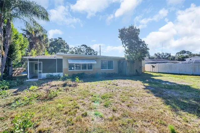 a front view of house with yard and trees in the background