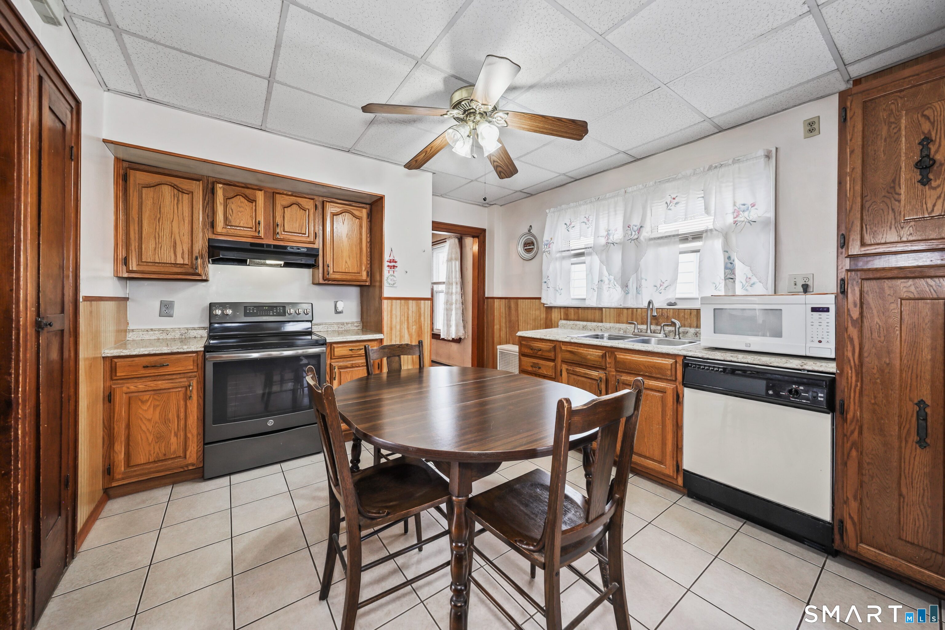 33 West View Street Waterbury, CT 06706 - Photo 13 of 29 a kitchen with stainless steel appliances granite countertop a stove a sink dishwasher a refrigerator with a dining table and chairs