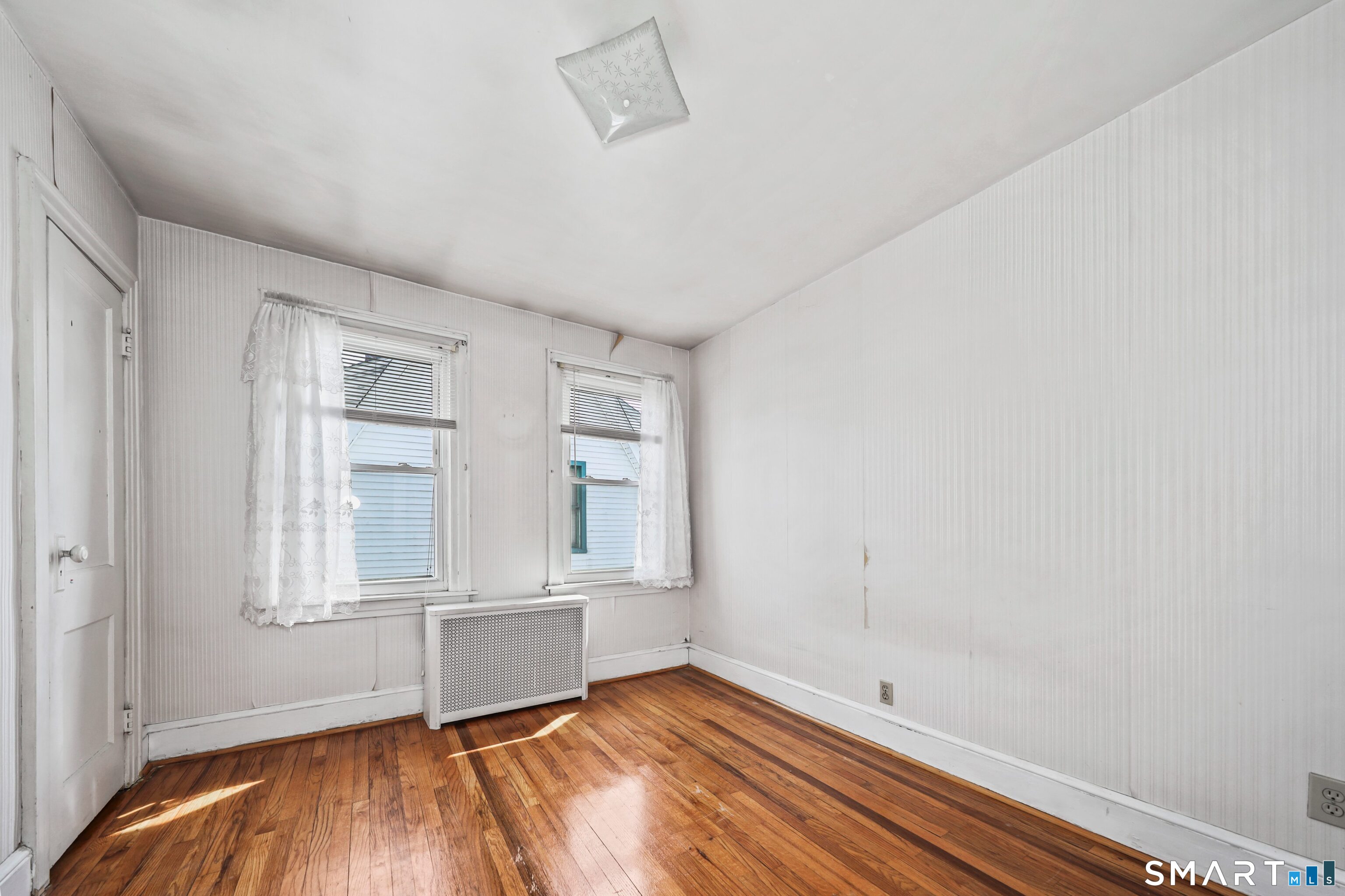 33 West View Street Waterbury, CT 06706 - Photo 21 of 29 an empty room with wooden floor and windows