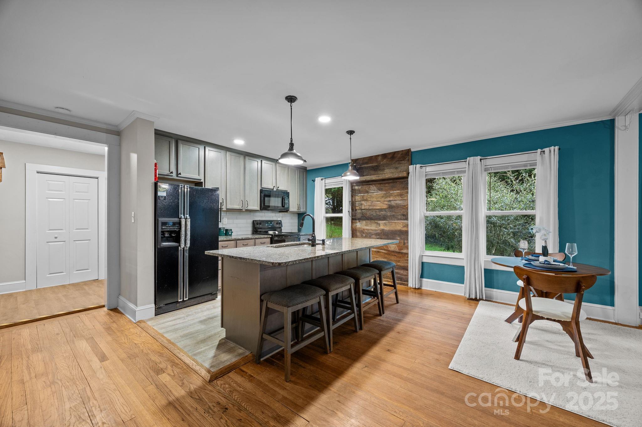 300 Gap Creek Road Fletcher, NC 28732 - Photo 16 of 48 a kitchen with stainless steel appliances kitchen island granite countertop a refrigerator a stove a oven a dining table and chairs with wooden floor