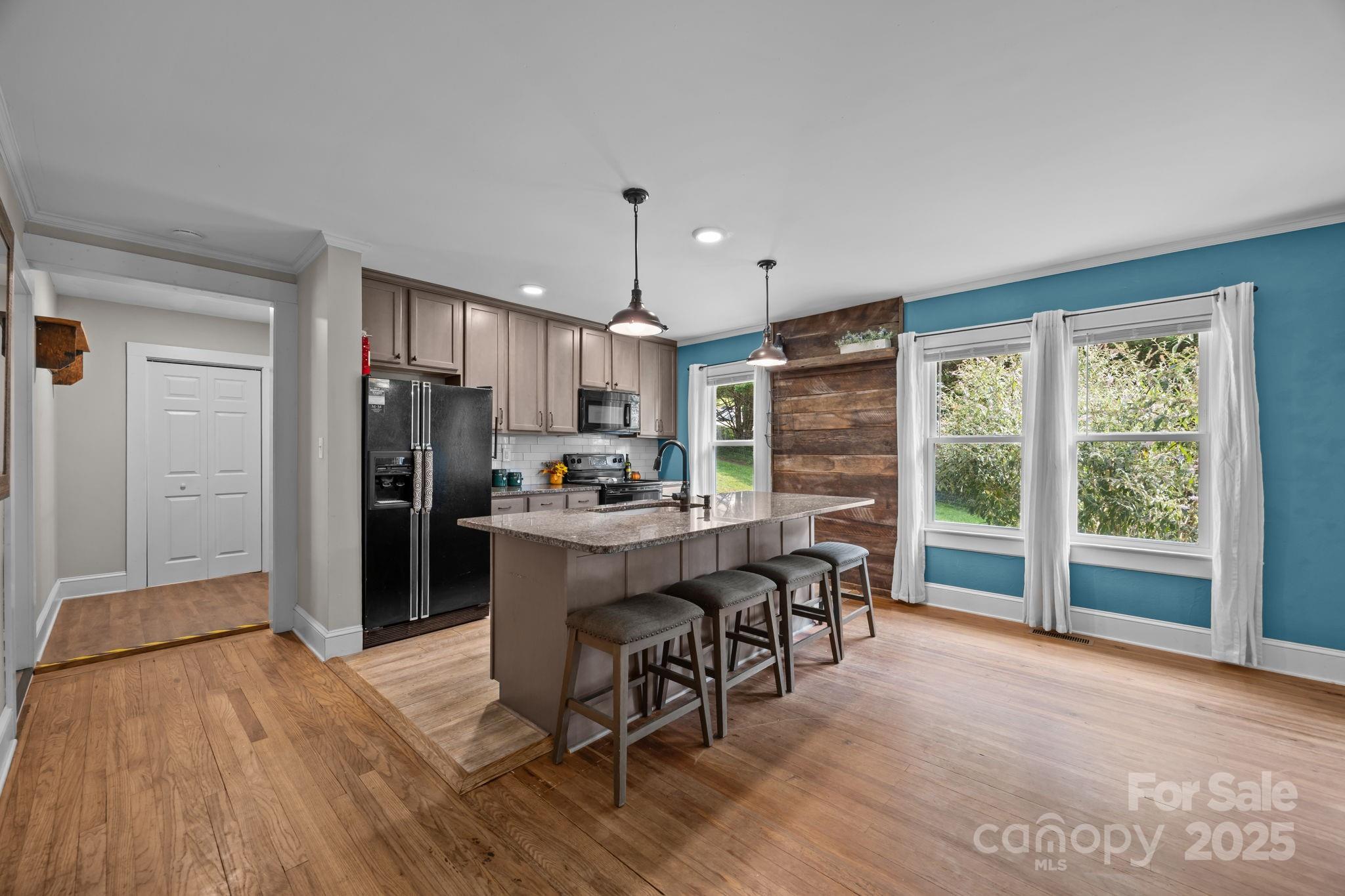 300 Gap Creek Road Fletcher, NC 28732 - Photo 20 of 48 a kitchen with stainless steel appliances a dining table chairs refrigerator and cabinets