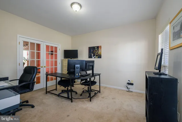 a view of a workspace with furniture and a window