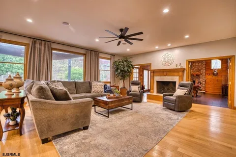 a living room with furniture kitchen view and a large window