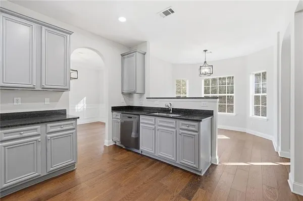 a kitchen with cabinets appliances and a wooden floor