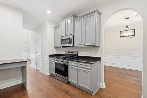 a kitchen with granite countertop a refrigerator sink and microwave