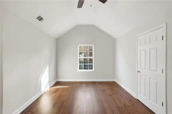 a view of an empty room with wooden floor