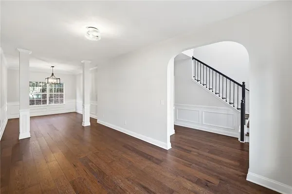 an empty room with wooden floor cabinet and windows