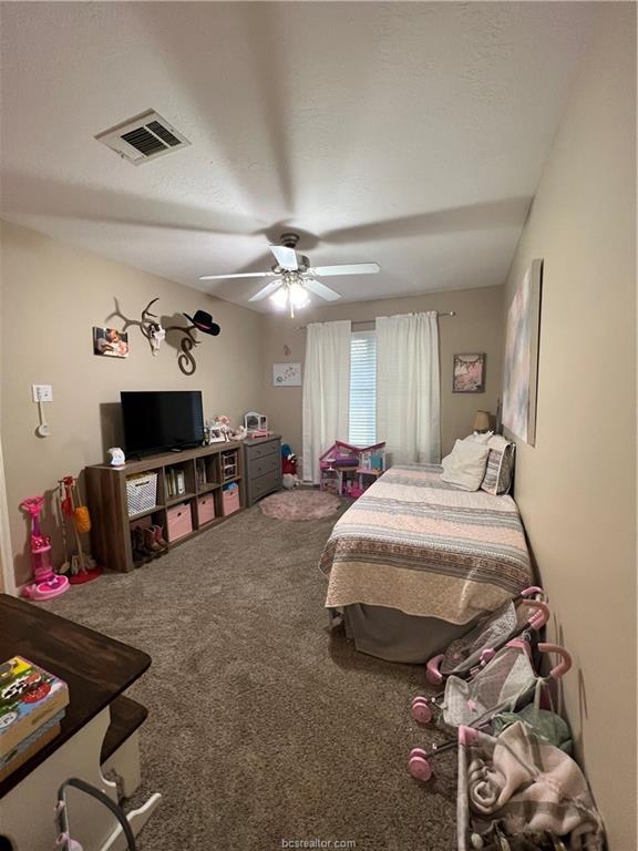 11349 North Dowling Road College Station, TX 77845 - Photo 12 of 16 a spacious bedroom with a bed a couch and a flat screen tv