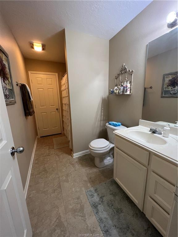 11349 North Dowling Road College Station, TX 77845 - Photo 13 of 16 a bathroom with a toilet sink and mirror