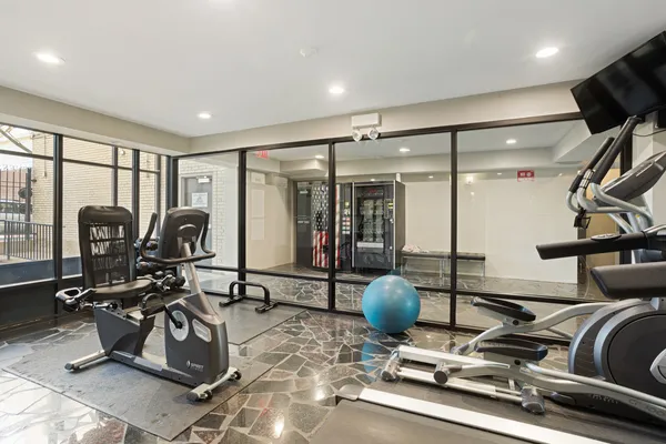 a room with gym equipment and large mirror