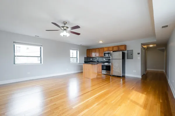 a view of kitchen with wooden floor and a refrigerator