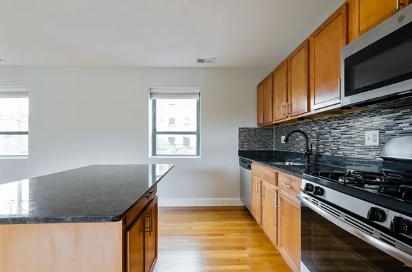 a kitchen with granite countertop a sink and a stove