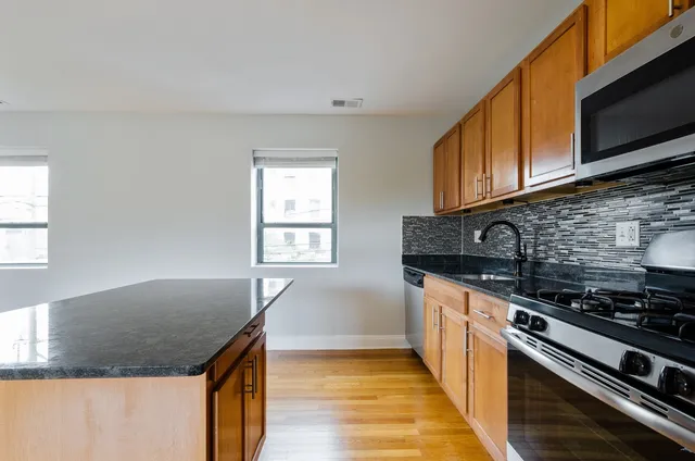 a kitchen with granite countertop a sink and a stove