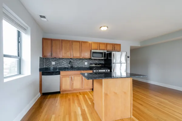 a kitchen with stainless steel appliances granite countertop a stove a sink and a refrigerator