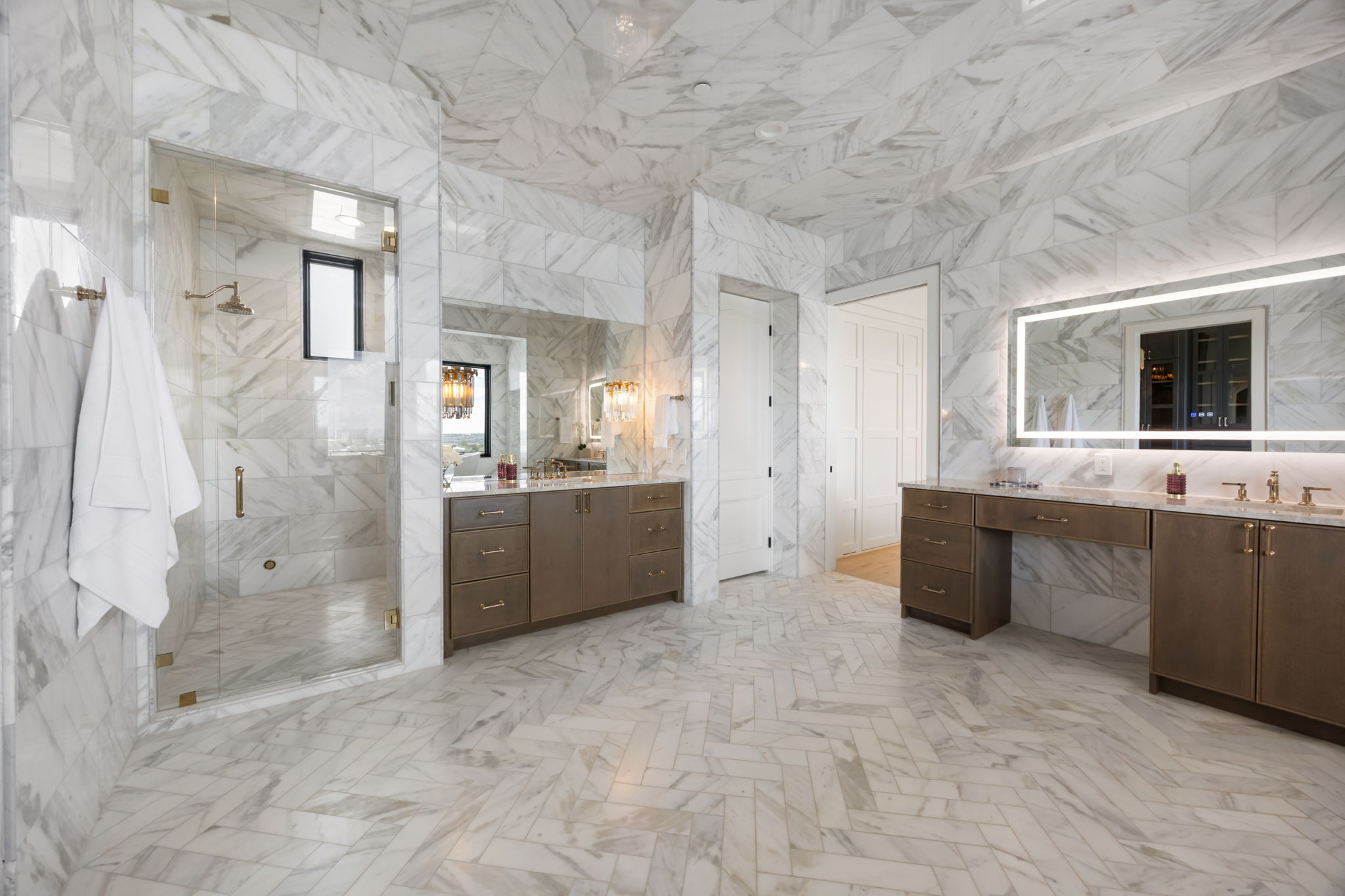 1496 Buffalo Gap Road Lakeway, TX 78734 - Photo 23 of 37 Marble-clad primary bathroom boasts a spacious shower and dual vanities with illuminated mirrors.