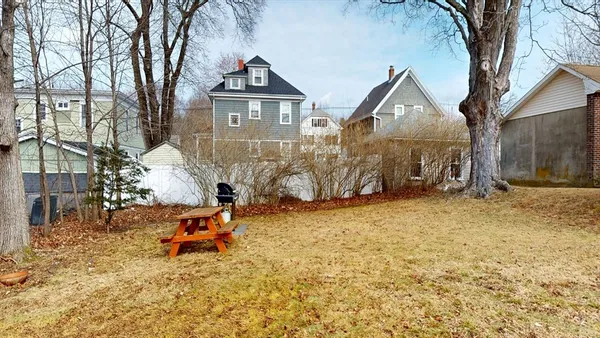 a backyard of a house with table and chairs