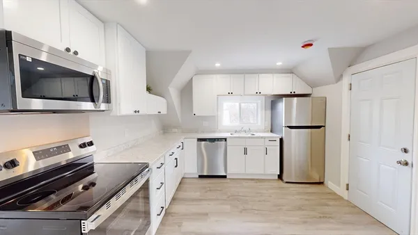 a kitchen with granite countertop a sink stainless steel appliances and cabinets