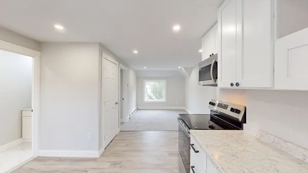 a kitchen with granite countertop a sink dishwasher stove and cabinets