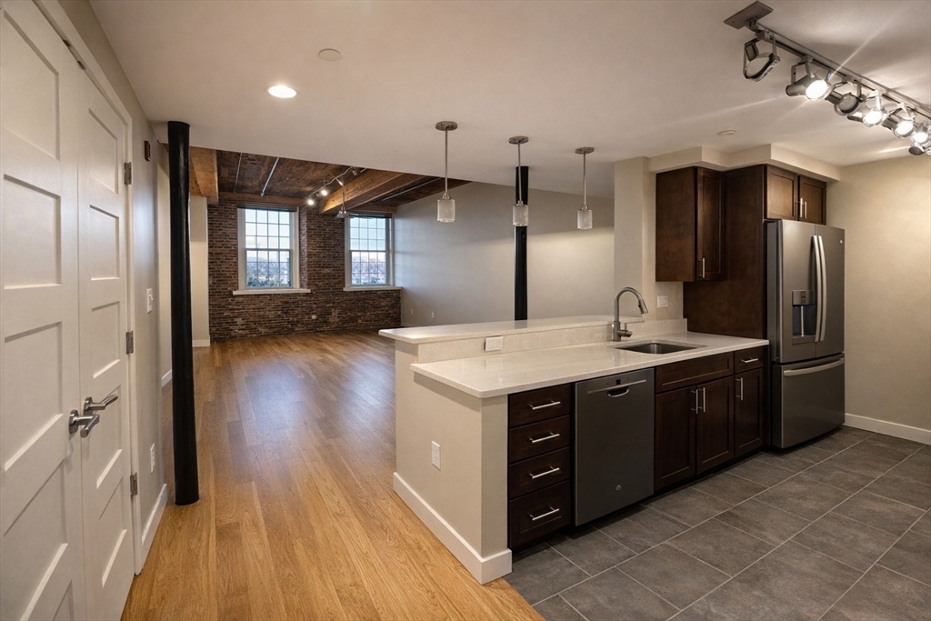 130 John Street, Unit 142 Lowell, MA 01852 - Photo 1 of 15 a kitchen with stainless steel appliances granite countertop a sink and a refrigerator