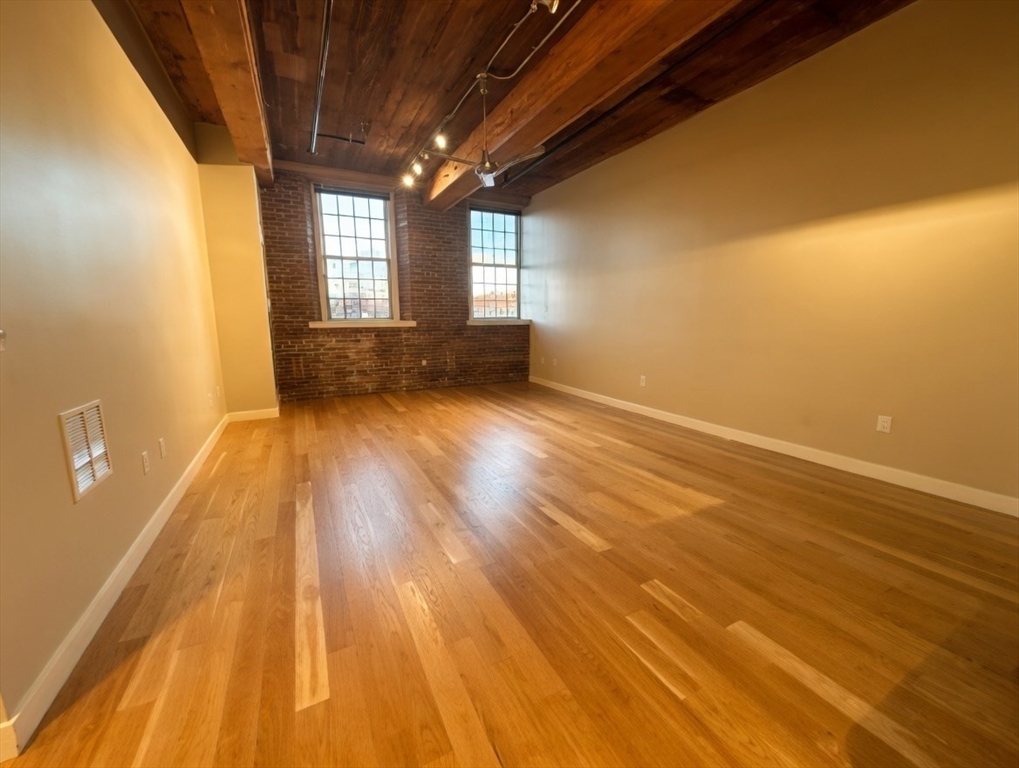 130 John Street, Unit 142 Lowell, MA 01852 - Photo 4 of 15 a view of empty room with wooden floor and fan
