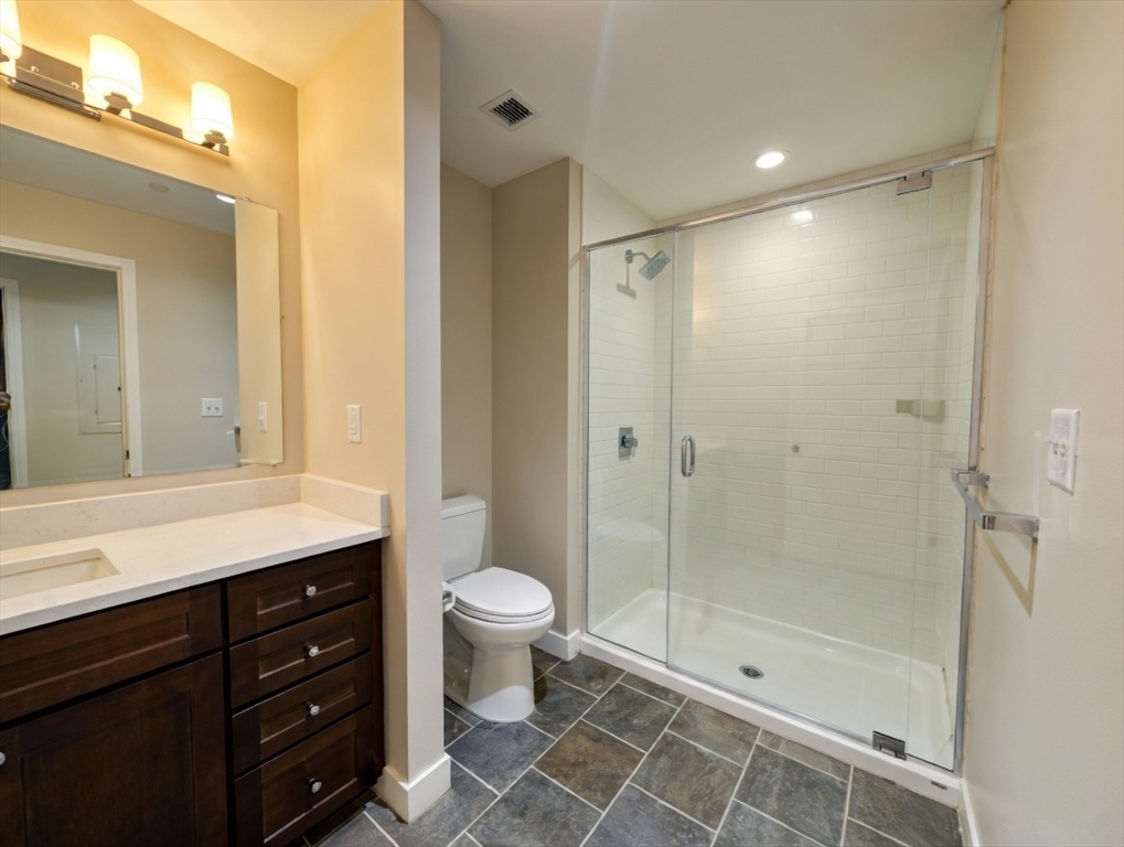 130 John Street, Unit 142 Lowell, MA 01852 - Photo 7 of 15 a bathroom with a shower a sink and a mirror