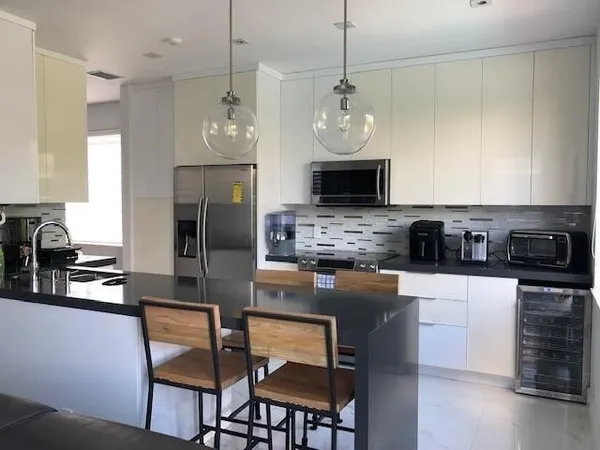 a kitchen with stainless steel appliances granite countertop a stove top oven a refrigerator a sink and a granite counter tops