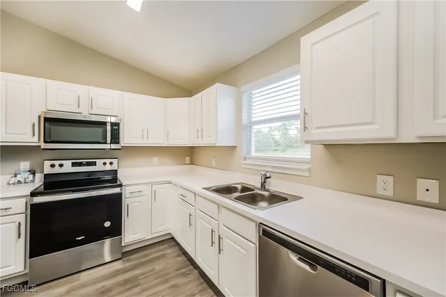 a kitchen with granite countertop white cabinets and white appliances