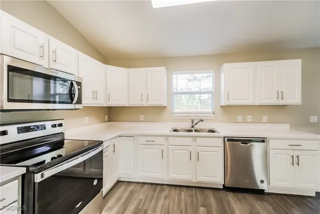 a kitchen with white cabinets stainless steel appliances and sink