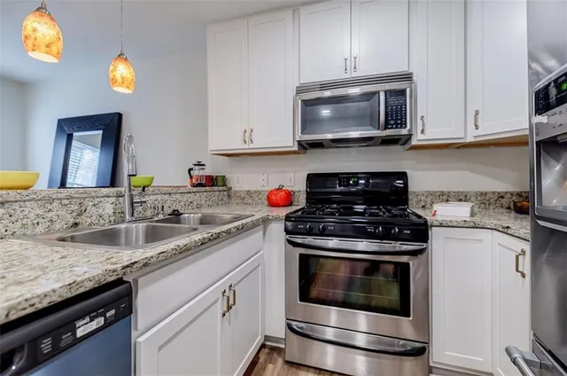 a kitchen with granite countertop a stove top oven microwave and cabinets