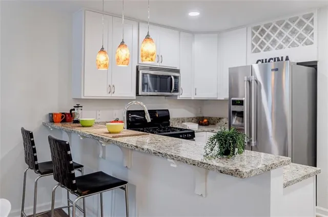 a kitchen with stainless steel appliances granite countertop a refrigerator sink and stove