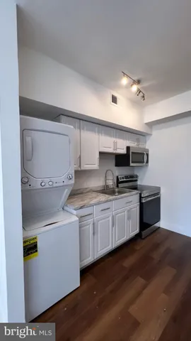 a kitchen with granite countertop a sink and cabinets