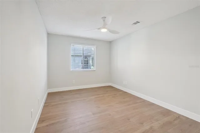 an empty room with fan and entrance