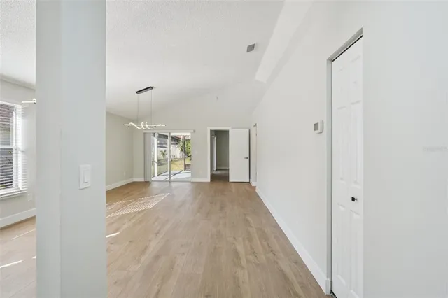 a view of a big room with wooden floor and windows