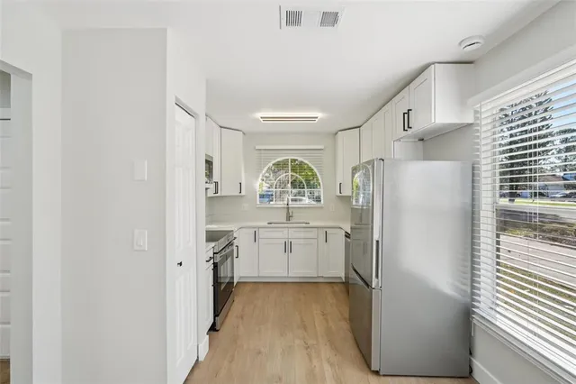a kitchen with refrigerator and window