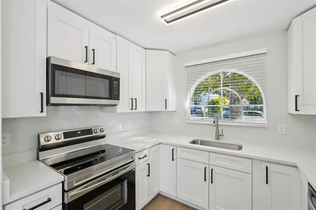a kitchen with appliances a sink and a window