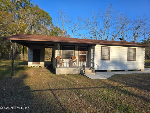 a view of a house with backyard porch and sitting area