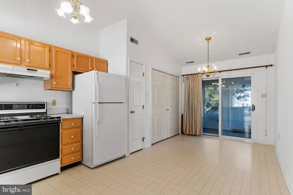 a kitchen with stainless steel appliances granite countertop a refrigerator a stove a sink dishwasher and a refrigerator with wooden floor