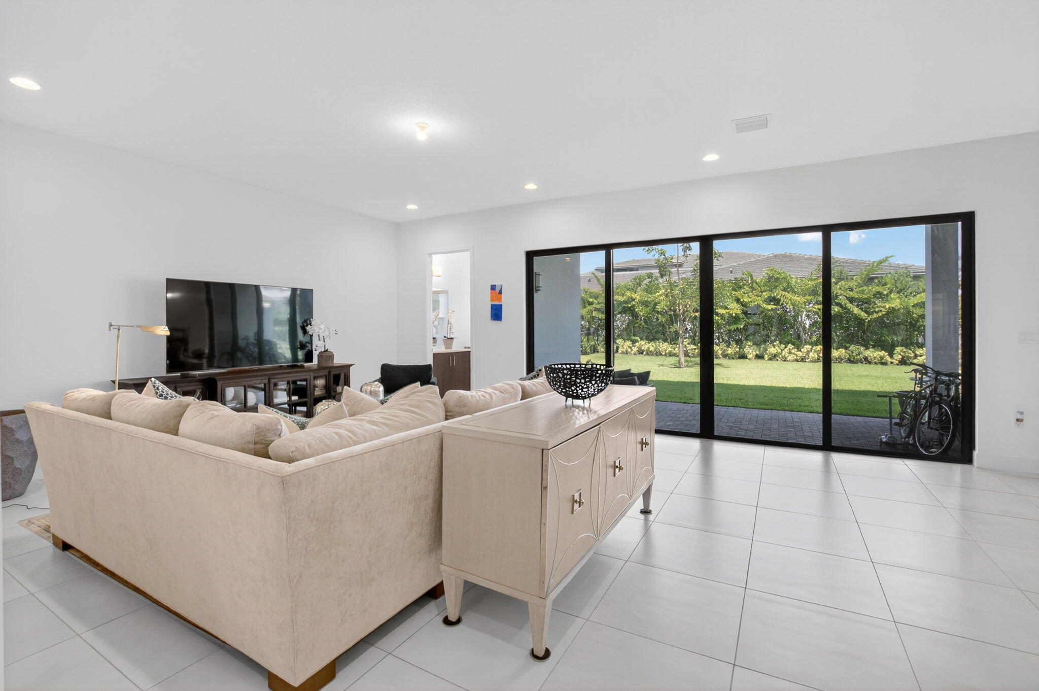20278 Bandon Dunes Road Boca Raton, FL 33434 - Photo 19 of 113 a living room with furniture a flat screen tv and a floor to ceiling window