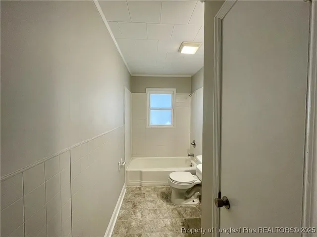 a bathroom with a granite countertop sink a toilet and shower