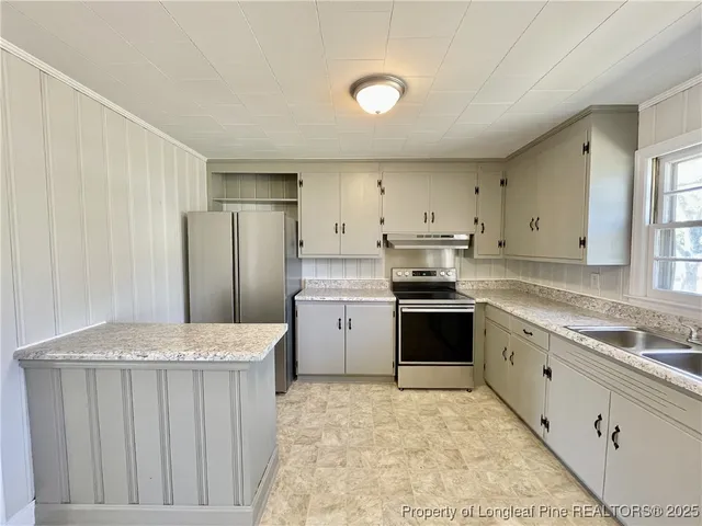 a kitchen with a stove a sink and a refrigerator