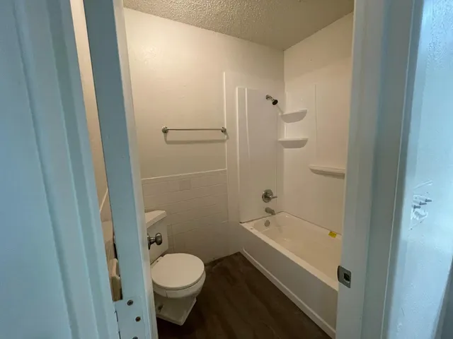 a bathroom with a granite countertop toilet and a shower