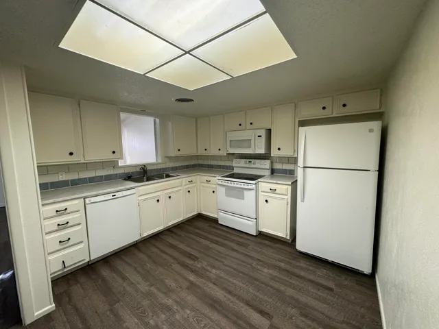a kitchen with white cabinets and white appliances