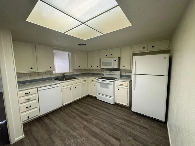 a kitchen with white cabinets and white appliances