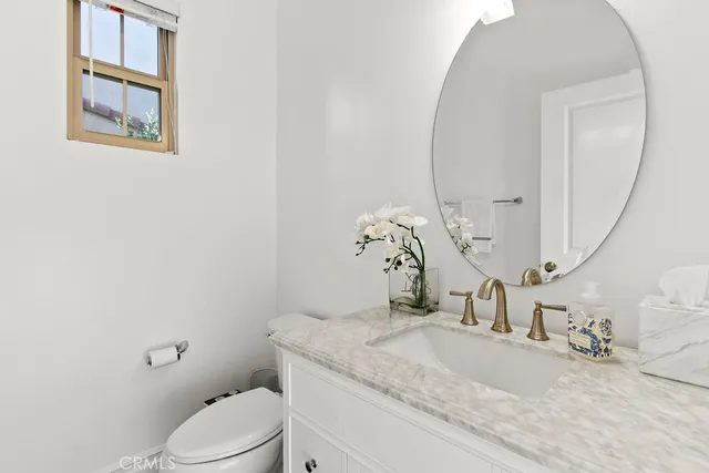 a bathroom with a granite countertop sink a toilet and a mirror