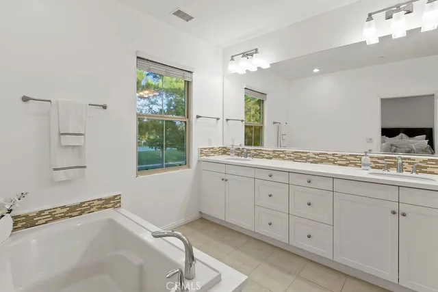 a spacious bathroom with double sink and a window