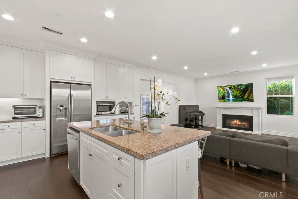 120 Gemstone Irvine, CA 92620 - Photo 8 of 43 a kitchen with a refrigerator a sink dishwasher a oven with white cabinets and wooden floor