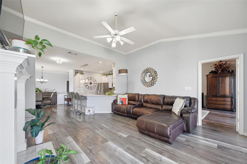 1904 Signal Ridge Place Rockwall, TX 75032 - Photo 7 of 23 Living room with ornamental molding, vaulted ceiling, light wood-style flooring, a ceiling fan, and a chandelier