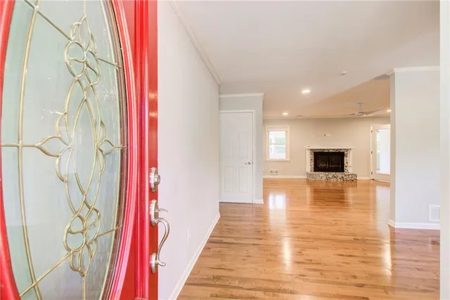 a view of a hallway with wooden floor and a bathroom